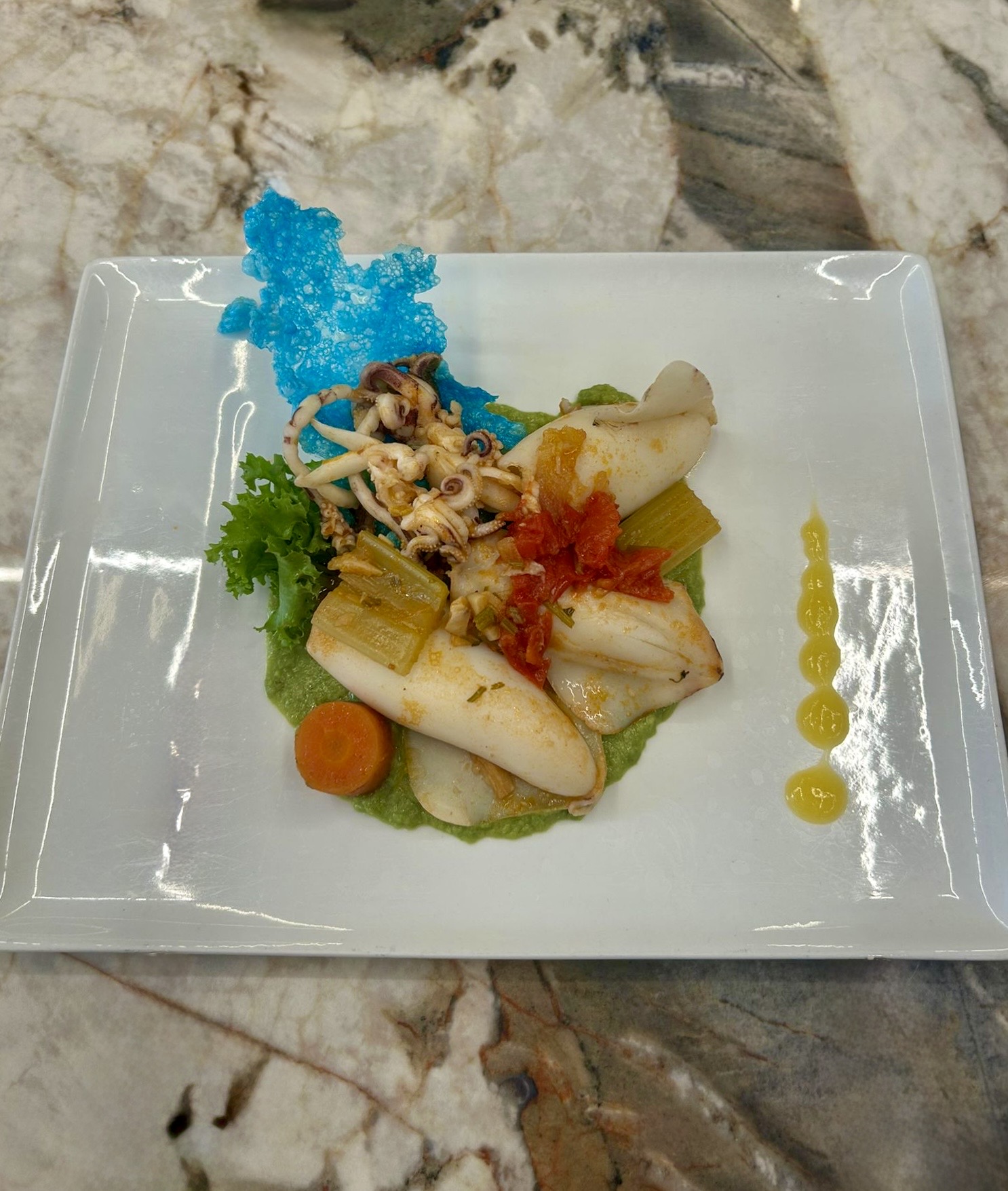 Calamaretti alla pescatora su vellutata di piselli
